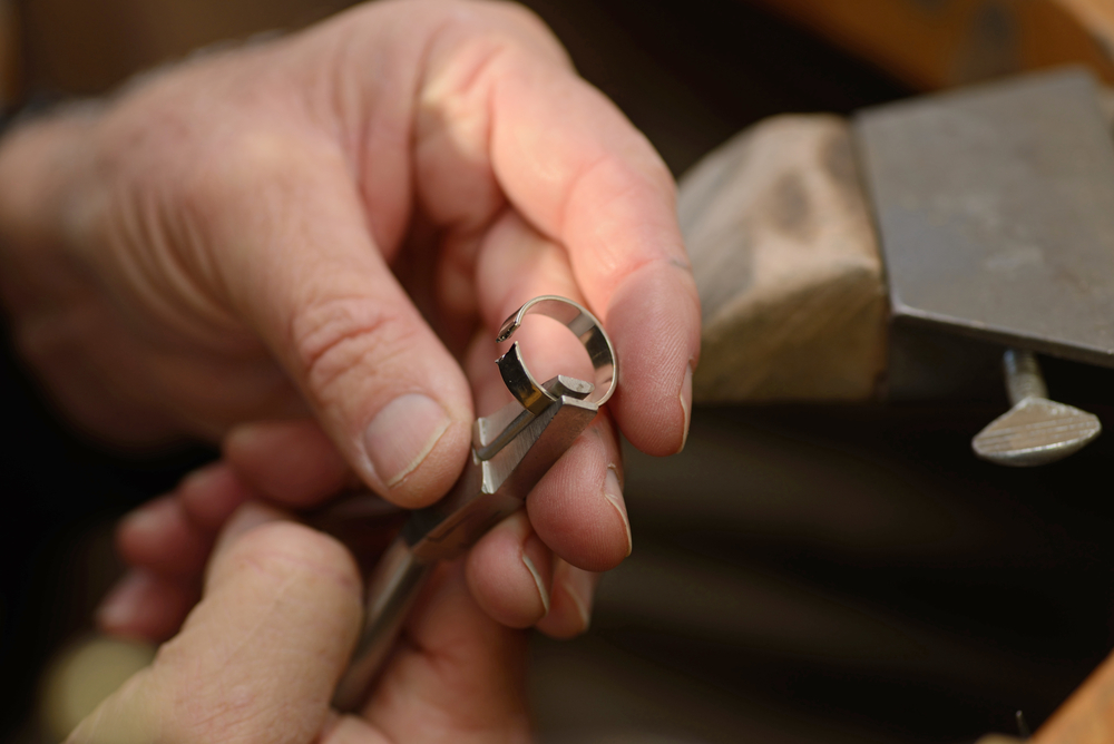 Jewelry resizing a gold ring.